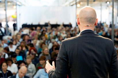 Picture of man talking in front of crowd